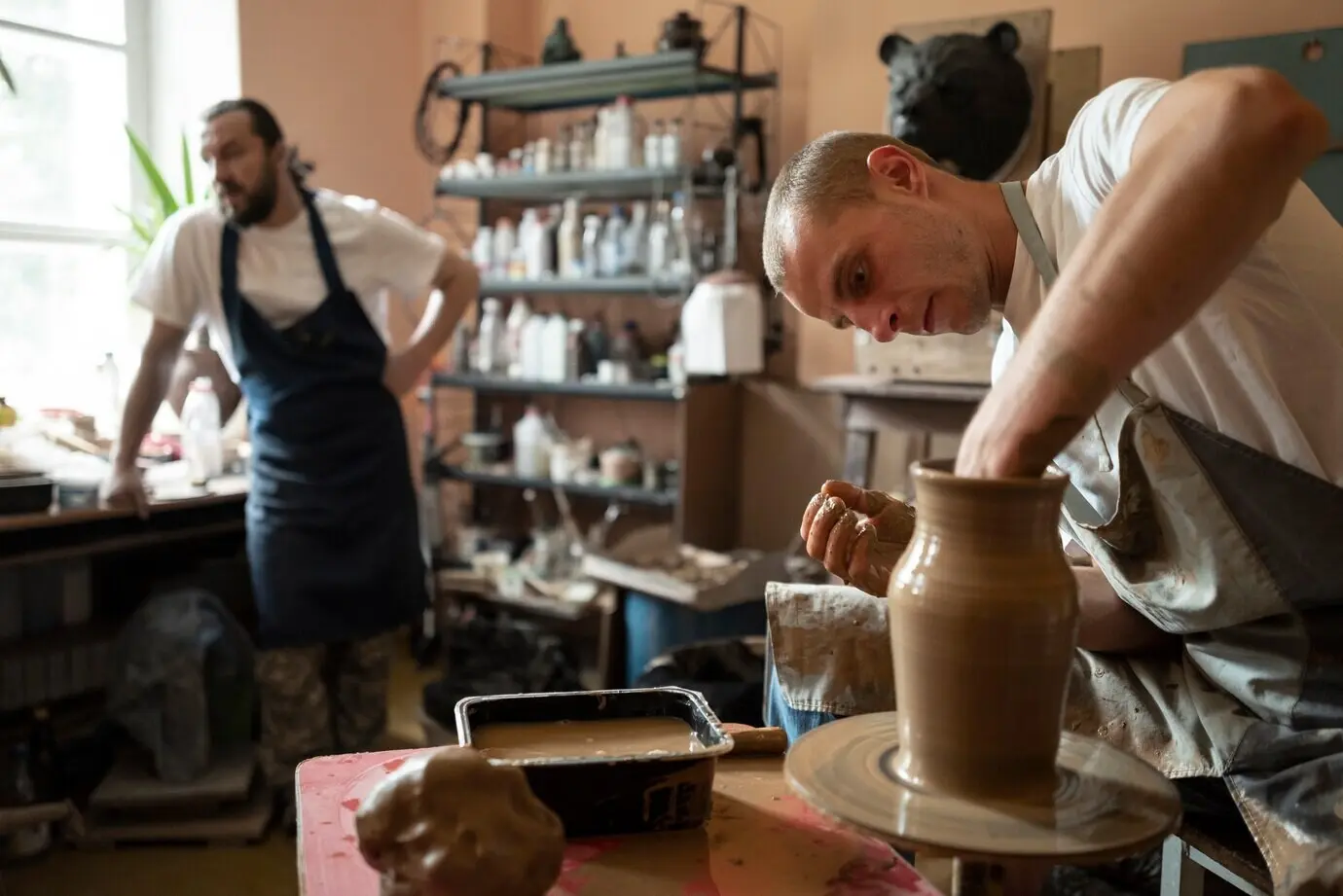 Seitenansicht eines Mannes beim Töpfern.